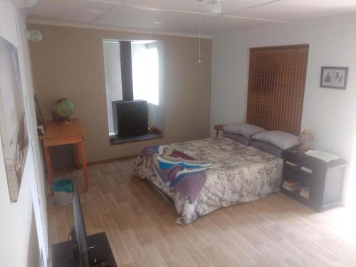 - une chambre avec un lit et une télévision dans l'établissement Fisherhaven Guest House, à Hermanus
