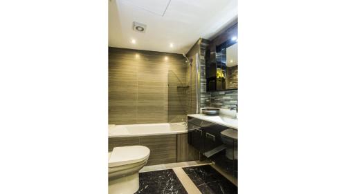 Pass the Keys Spacious Luxury Apartment in the Heart of London في لندن: حمام مع مرحاض وحوض استحمام ومغسلة