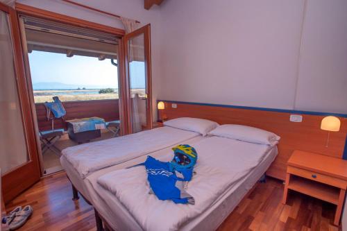 a bed in a room with a large window at Hotel Caneo in Fossalòn