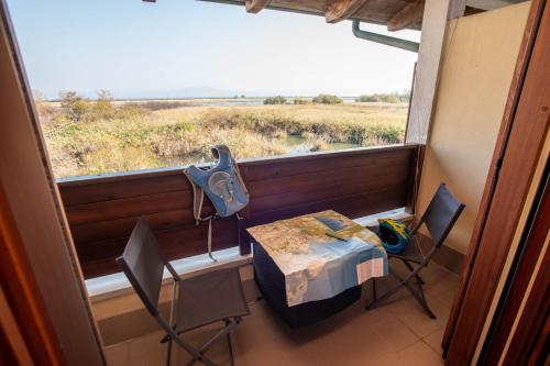 a table and chairs in a room with a large window at Hotel Caneo in Fossalòn