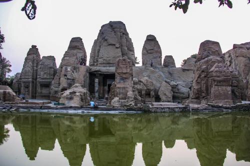 a temple in front of a body of water at Prakriti Aalay - Riverside Mountain View Boutique Eco Resort in Dharamshala