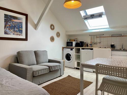 un salon avec un canapé et une table et une cuisine dans l'établissement La Cabane du Parc, à Orléans