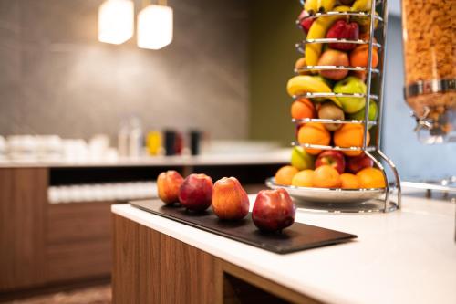 a tray of fruit on a counter with a rack of fruit at Nestos Hotel in Xanthi