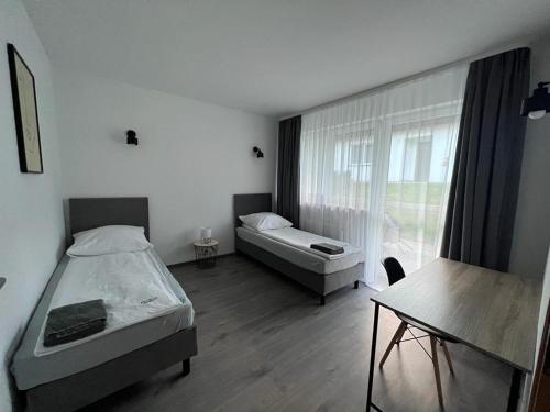 a bedroom with two beds and a table and a window at Petrico Camp Resort in Krzywopłoty