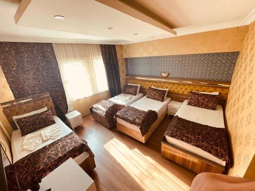 a hotel room with three beds and a window at Meta Hotel in Bursa