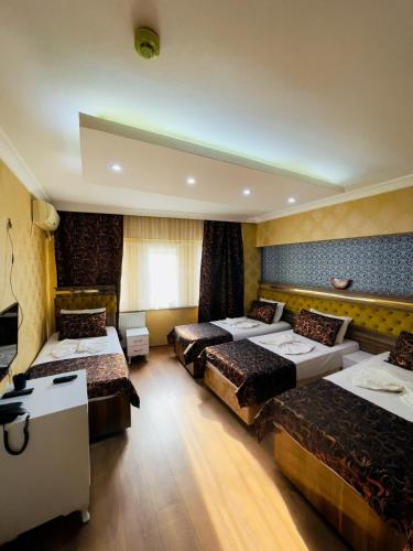 a hotel room with four beds and a television at Meta Hotel in Bursa