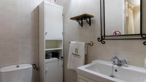 bagno con lavandino, servizi igienici e specchio di Bodega Ciprés Benaoján by Ruralidays a Benaoján