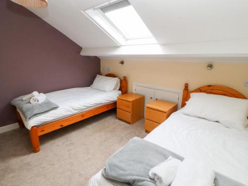 two beds in a room with a skylight at Cobbleken in Cockermouth
