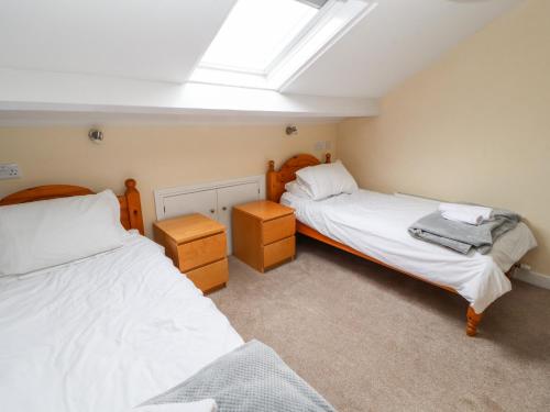 a bedroom with two beds and a skylight at Cobbleken in Cockermouth