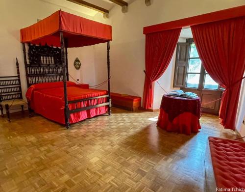 a bedroom with a canopy bed and a wooden floor at Résidence Cala Montgo in L'Escala