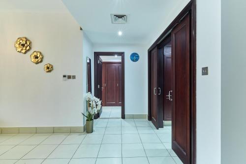 a hallway with two doors and a vase of flowers at Golden Homes 1BR Reehan miniPalais Beside Burjh & Dubai mall Downtown in Dubai
