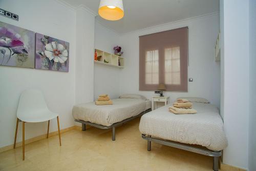 1 dormitorio con 2 camas, silla y ventana en 241 Cabo Roig Sea View-Alicante Holiday, en Cabo Roig