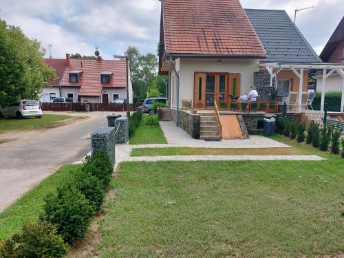 a person sitting on the porch of a house at Titi Boutique Apartmanok in Bükfürdő
