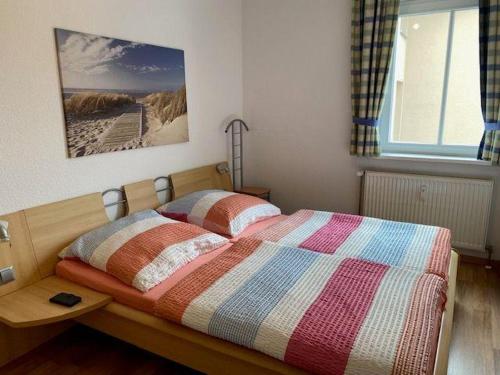 um quarto com uma cama com uma fotografia na parede em Haus-Olymp-Apartement-01-Kuehlungsborn-nur-50-m-bis-zum-Strand-ca-50-m2-2-Raeume-sehr-gepflegt em Kühlungsborn