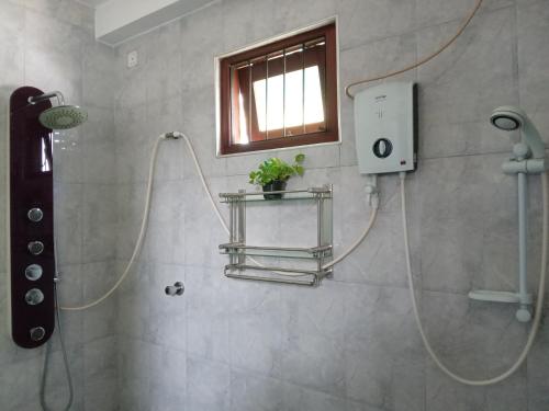 eine Dusche mit einem Schlauch im Bad mit einem Fenster in der Unterkunft Lake Life Villa in Ambalangoda