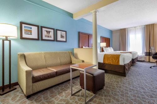 a hotel room with a bed and a couch at Comfort Suites Southport - Oak Island in Southport