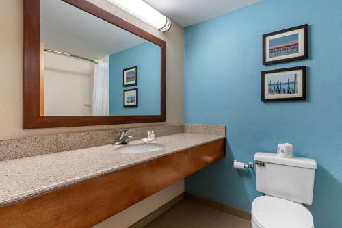 a bathroom with a sink and a mirror and a toilet at Comfort Suites Southport - Oak Island in Southport