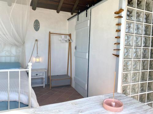 a room with a bed and a table with a window at Casa da Aldeia in Santa Bárbara de Nexe