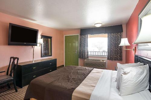 a hotel room with a bed and a flat screen tv at Econo Lodge Dalhart Hwy 54 - Hwy 287 in Dalhart