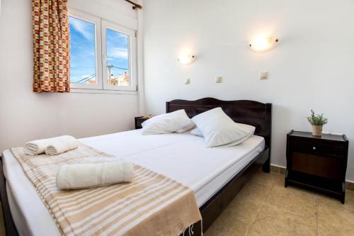 um quarto com uma cama grande e uma janela em Apartments Ralitsa em Limenaria