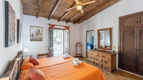 a bedroom with a large bed and a ceiling fan at Los Olivos Antequera - Los Nogales by Ruralidays in Antequera
