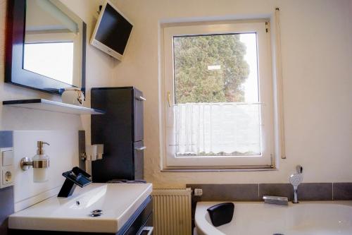MünstermaifeldにあるSchöne Wohnung Kleiner Onkel auf idyllischem Reiterhof nahe Burg Eltzの洗面台と大きな窓のあるバスルーム