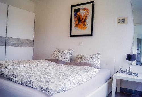 MünstermaifeldにあるSchöne Wohnung Kleiner Onkel auf idyllischem Reiterhof nahe Burg Eltzのベッドと壁に絵が飾られた寝室