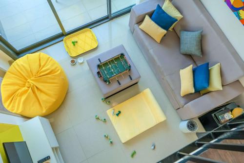 una vista aérea de una sala de estar con almohadas amarillas y azules en Cassia Phuket, en Bang Tao Beach