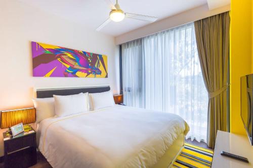 a hotel room with a bed and a large window at Cassia Phuket, part of Banyan Group in Bang Tao Beach