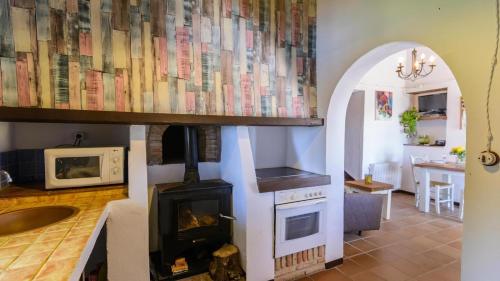 ein Wohnzimmer mit einem Herd und einer Mikrowelle in der Unterkunft Torcalillos Antequera - La Joya by Ruralidays in Antequera