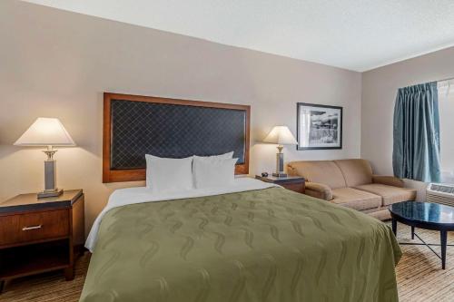 a hotel room with a large bed and a couch at Quality Inn Denver Tech Center in Englewood
