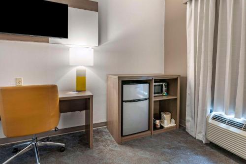 a room with a desk and a chair and a tv at Comfort Inn & Suites in Shelbyville