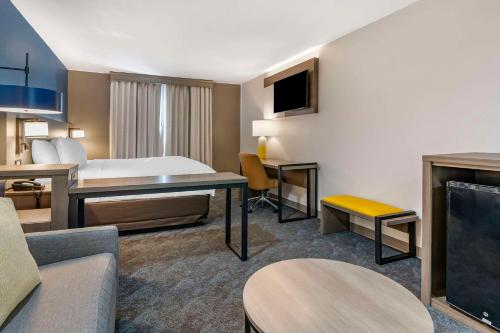 a hotel room with a bed and a living room at Comfort Inn & Suites in Shelbyville