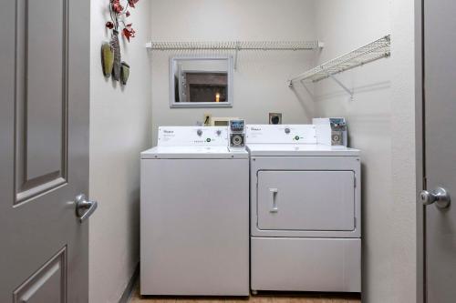 a white laundry room with a washer and dryer at Comfort Inn & Suites in Shelbyville