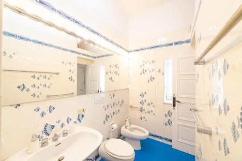 a white bathroom with a toilet and a sink at Villa Le Tuie by Elite Villas in Capri