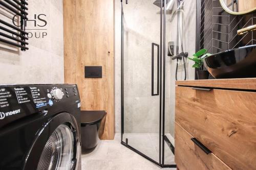 a laundry room with a washing machine and a shower at Elegancki apartament w centrum miasta-Kazimierz in Krakow
