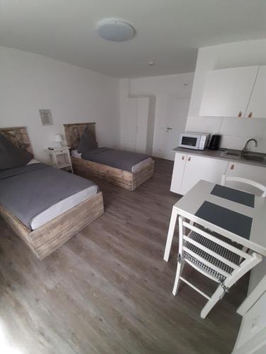 Zimmer mit 2 Betten, einem Tisch und einer Küche in der Unterkunft Pension Asche in Münster