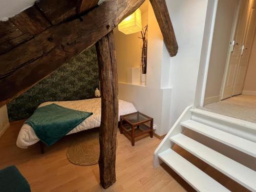 a small room with a bed and a staircase at *La douce étape des Châteaux * in Bracieux