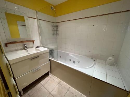 a bathroom with a bath tub and a sink at *La douce étape des Châteaux * in Bracieux