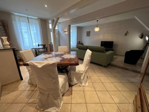 a living room with a table and a couch at *La douce étape des Châteaux * in Bracieux