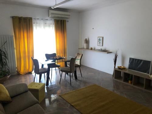 ein Wohnzimmer mit Tisch und Stühlen und einem Fernseher in der Unterkunft Apartamento Mar Azul in Vila Nova de Cerveira