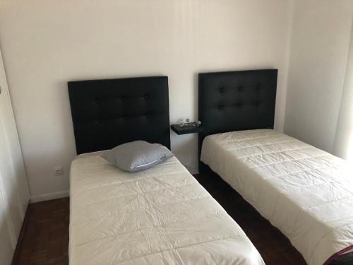 dos camas sentadas una al lado de la otra en una habitación en Apartamento Mar Azul, en Vila Nova de Cerveira