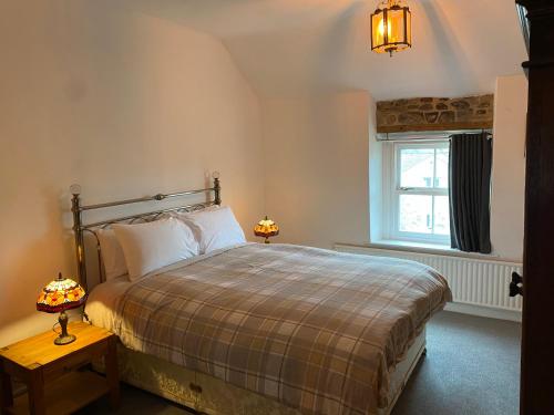 a bedroom with a bed and a window at Jasmine Cottage in Bakewell