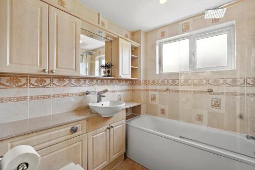 W łazience znajduje się umywalka i wanna. w obiekcie luxury 6 bedroom house in Aylesbury, Free parking w mieście Buckinghamshire