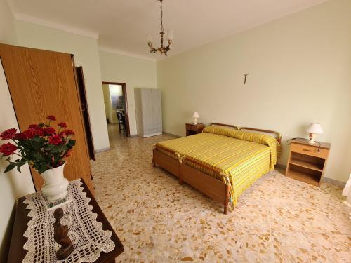 a bedroom with a bed and a vase with flowers in it at CASASALENTINA in Acquarica del Capo