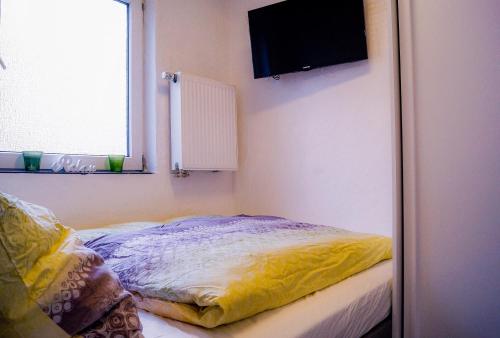 MünstermaifeldにあるModerne Ferienwohnung Black Beauty auf idyllischem Reiterhof nähe Burg Eltzのベッドルーム1室(ベッド1台、壁掛けテレビ付)