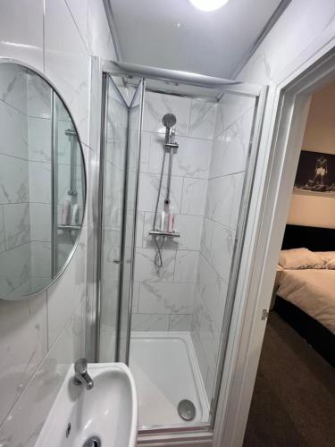 考文垂的住宿－Regent Cosy，带淋浴、盥洗盆和镜子的浴室