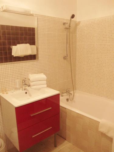 a bathroom with a red sink and a bath tub at L'auberge Camarguaise in Saintes-Maries-de-la-Mer