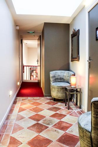 a lobby with a checkered floor and a table at Hôtel des Arts in Toulouse