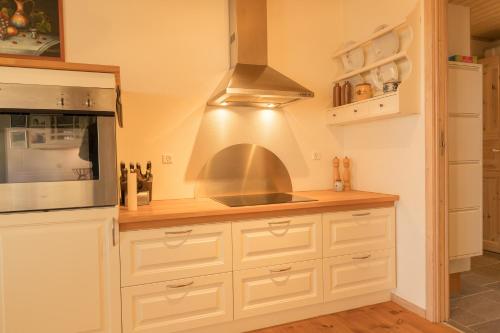 a kitchen with white cabinets and a stainless steel oven at Beautiful house in Tórshavn with a great view in Tórshavn